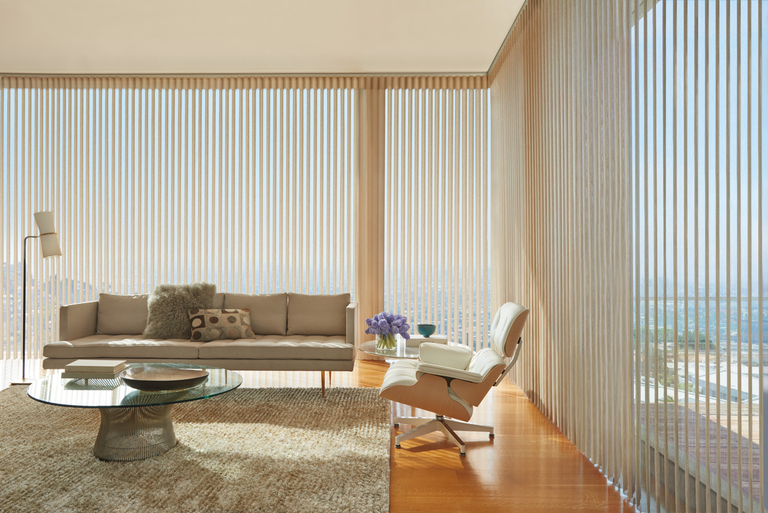 Living room with a couch and a big window, showcasing Hunter Douglas Luminette® Sheer Panels.