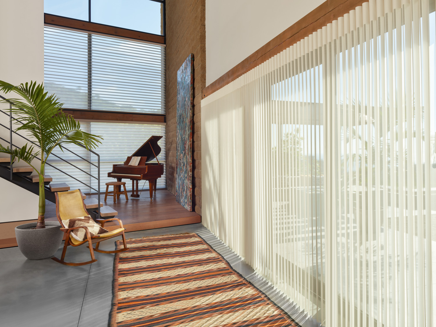 Elegant living room with a piano and window blinds, showcasing Hunter Douglas Luminette® Sheer Panels.