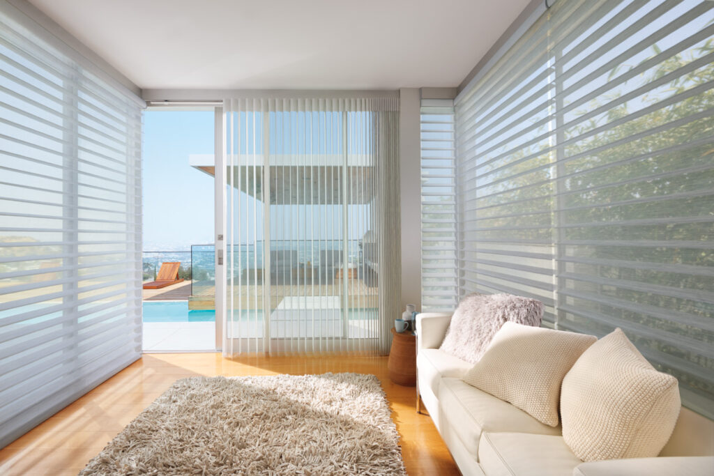A modern living room with Hunter Douglas Silhouette® Sheer Shades covering sliding glass doors.