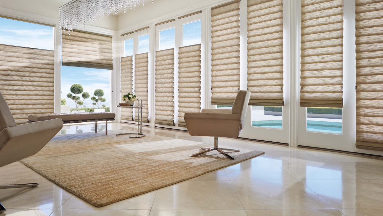 An inviting living room featuring a chair and a spacious window. Hunter Douglas Vignette® Roman Shades elevate the room's aesthetic.