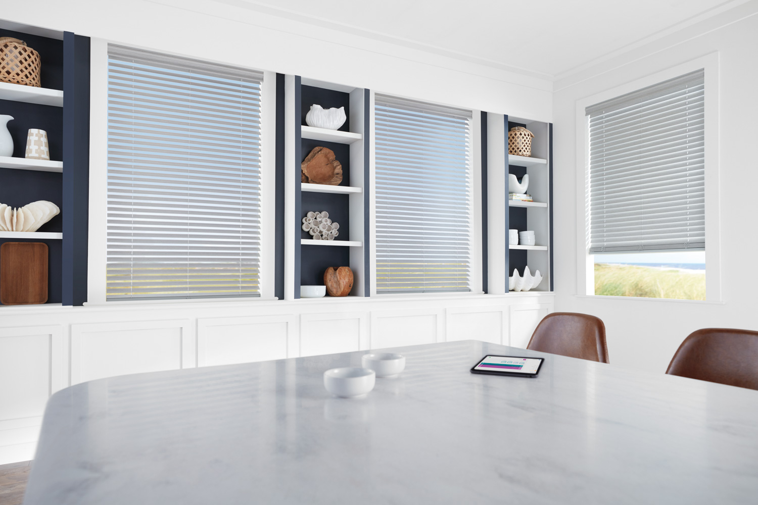 Contemporary dining room with white walls adorned by Hunter Douglas EverWood® Faux Wood Blinds.