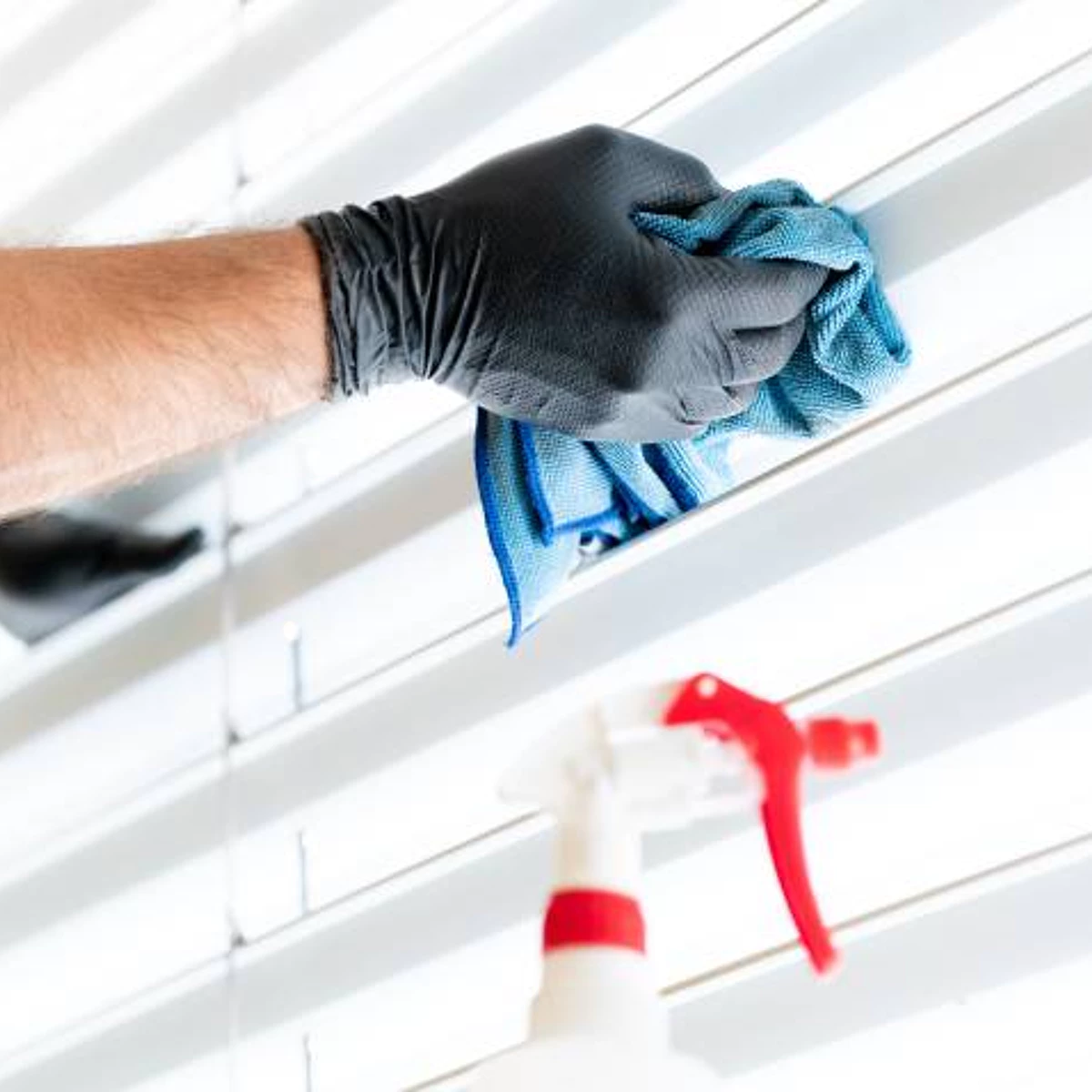 While wearing gloves, we spray cleaning solution onto window blinds, paying close attention to the process of cleaning the window shade.