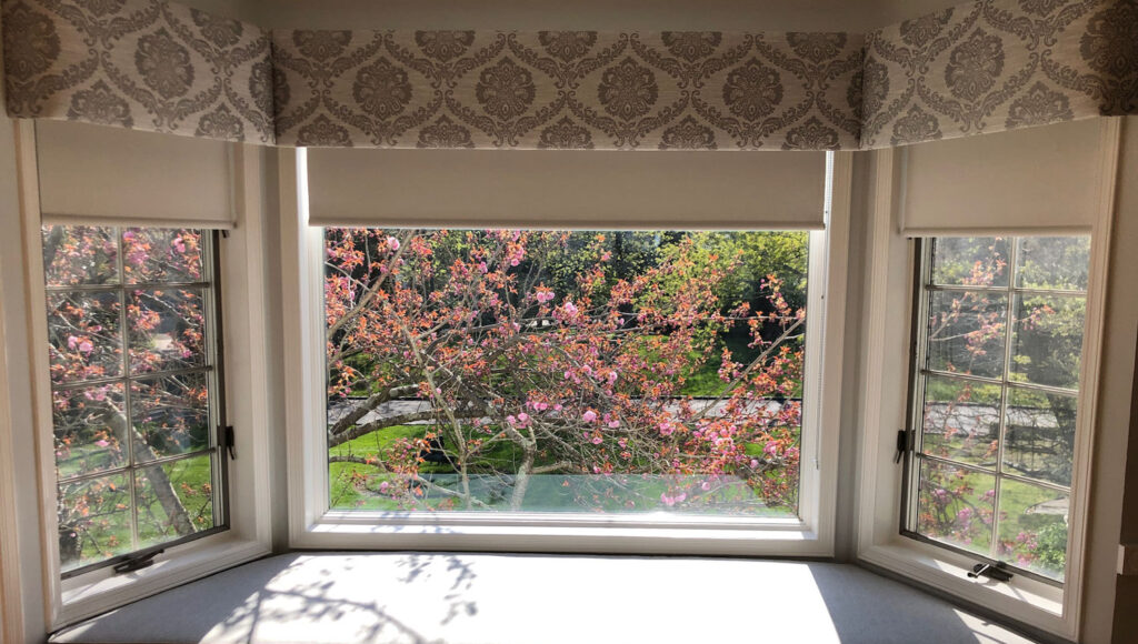 Custom upholstered cornice for bay window with elegant fabric and tailored design.