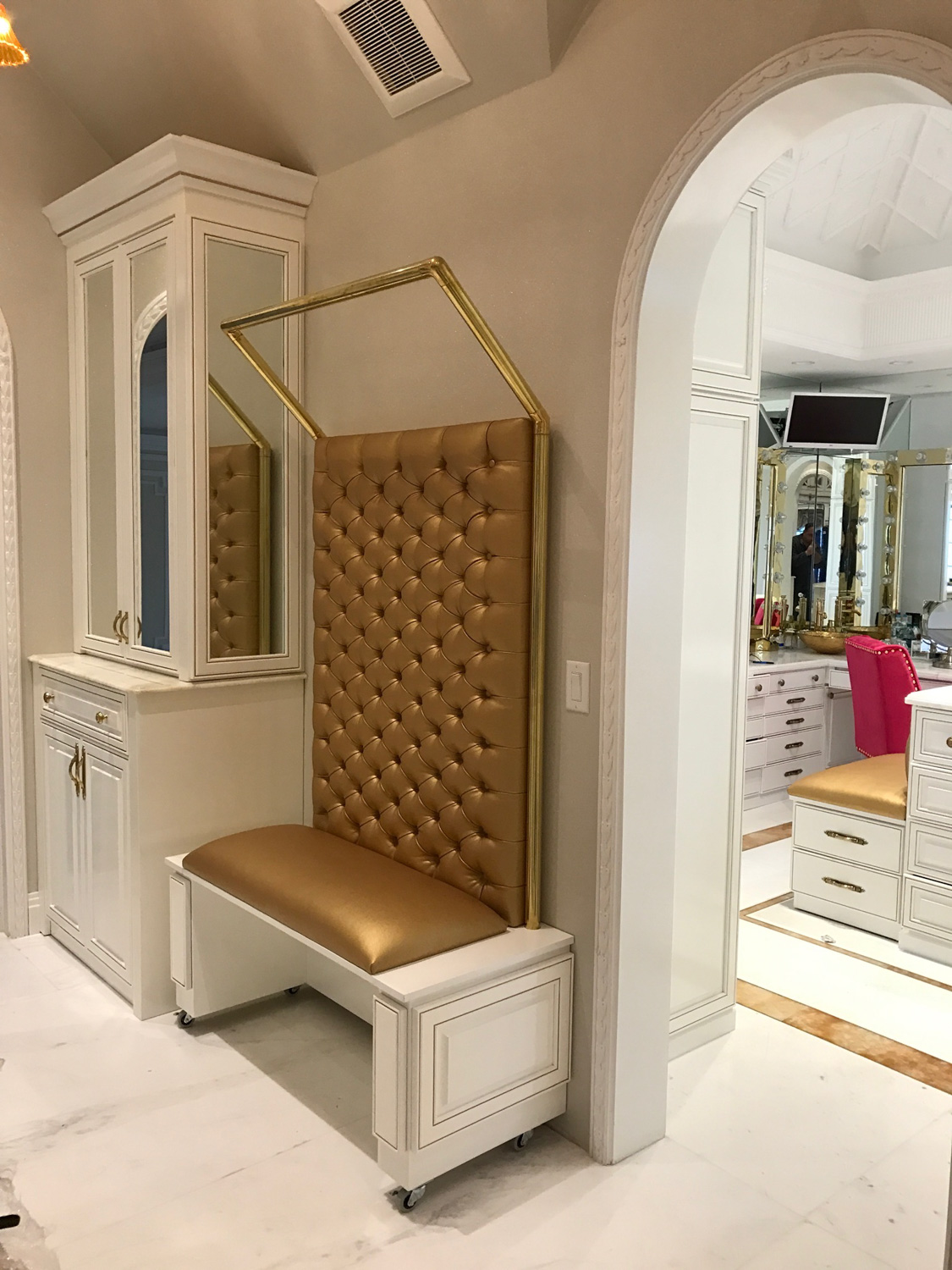 Elegant white vanity with gold accents and Custom Upholstered Tufted Bench.