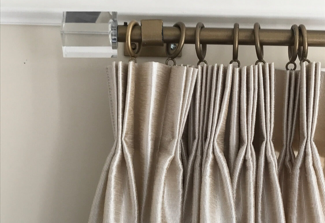 Drapery panels with elegant French pleats, adding a touch of sophistication to any room decor.