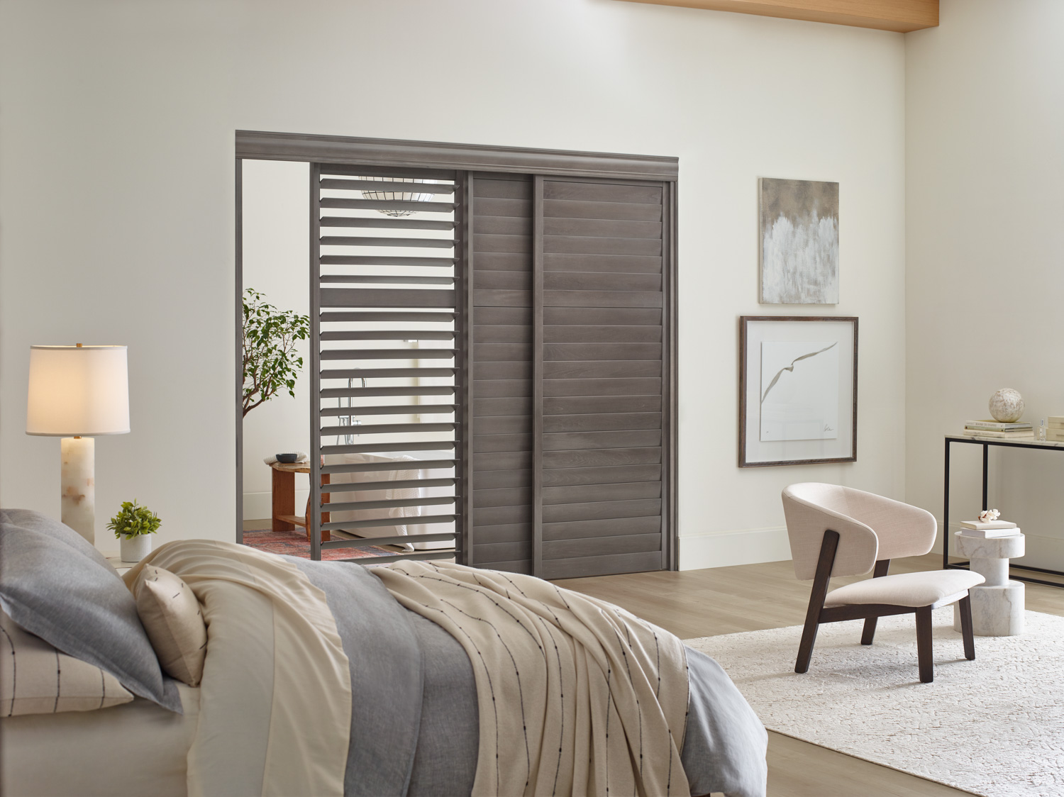 Sliding wood shutters in a bedroom, serving as a door, with a bed and chair.
