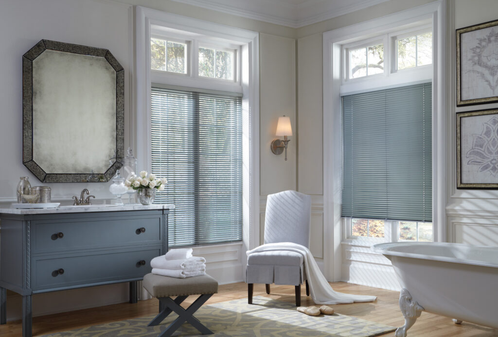 Bathroom with tub, sink, and window, showcasing Hunter Douglas Modern Precious Metals® Mini Blinds.