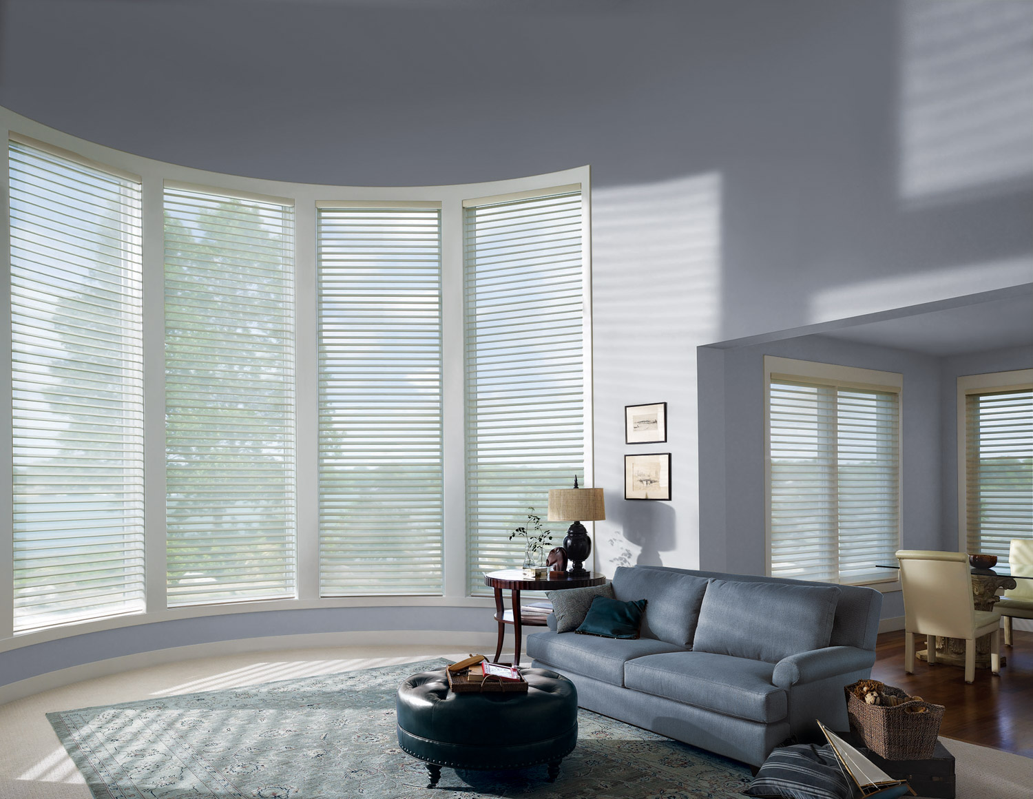 Modern living room with Hunter Douglas Silhouette® Sheer Shades in a bow window.