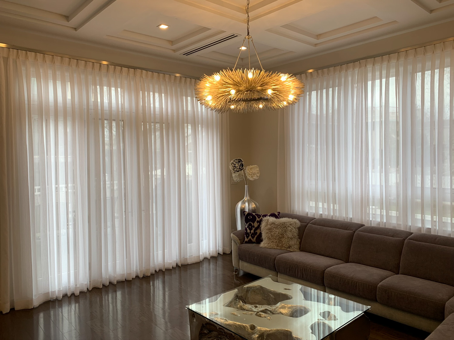 Living room with couch and sheer curtains with inverted pleat.